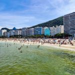 Praia de Copacabana, no Rio de Janeiro, com grande número de pessoas aproveitando um dia ensolarado