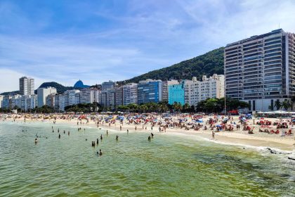 Praia de Copacabana, no Rio de Janeiro, com grande número de pessoas aproveitando um dia ensolarado